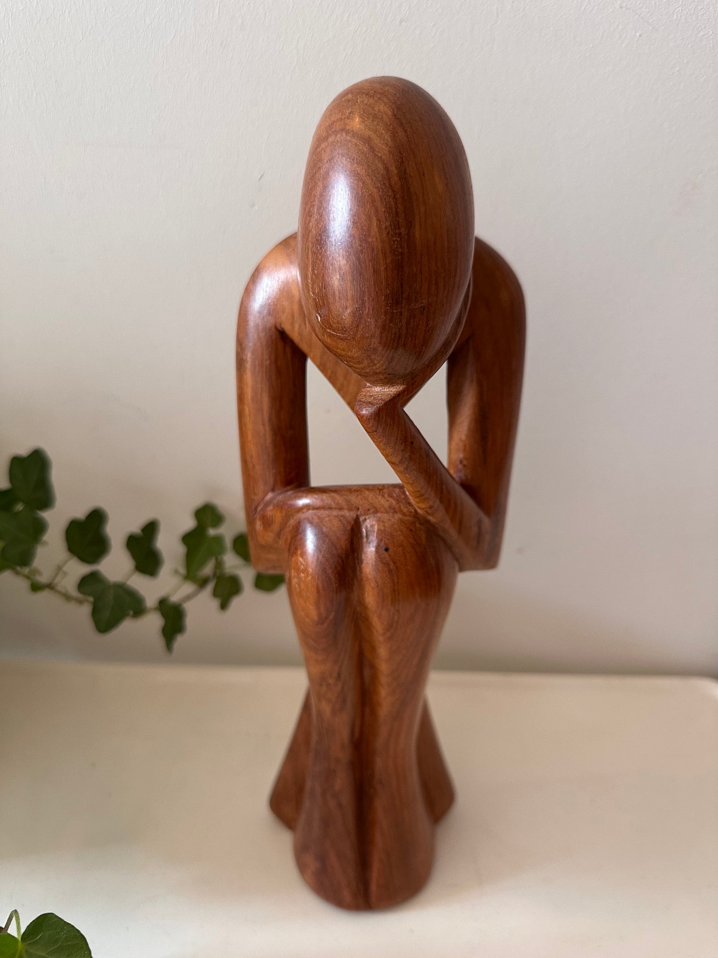 Zittende houten beeldje