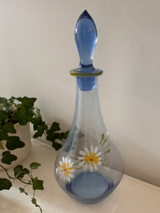 Karaf van blauw glas met margrietjes