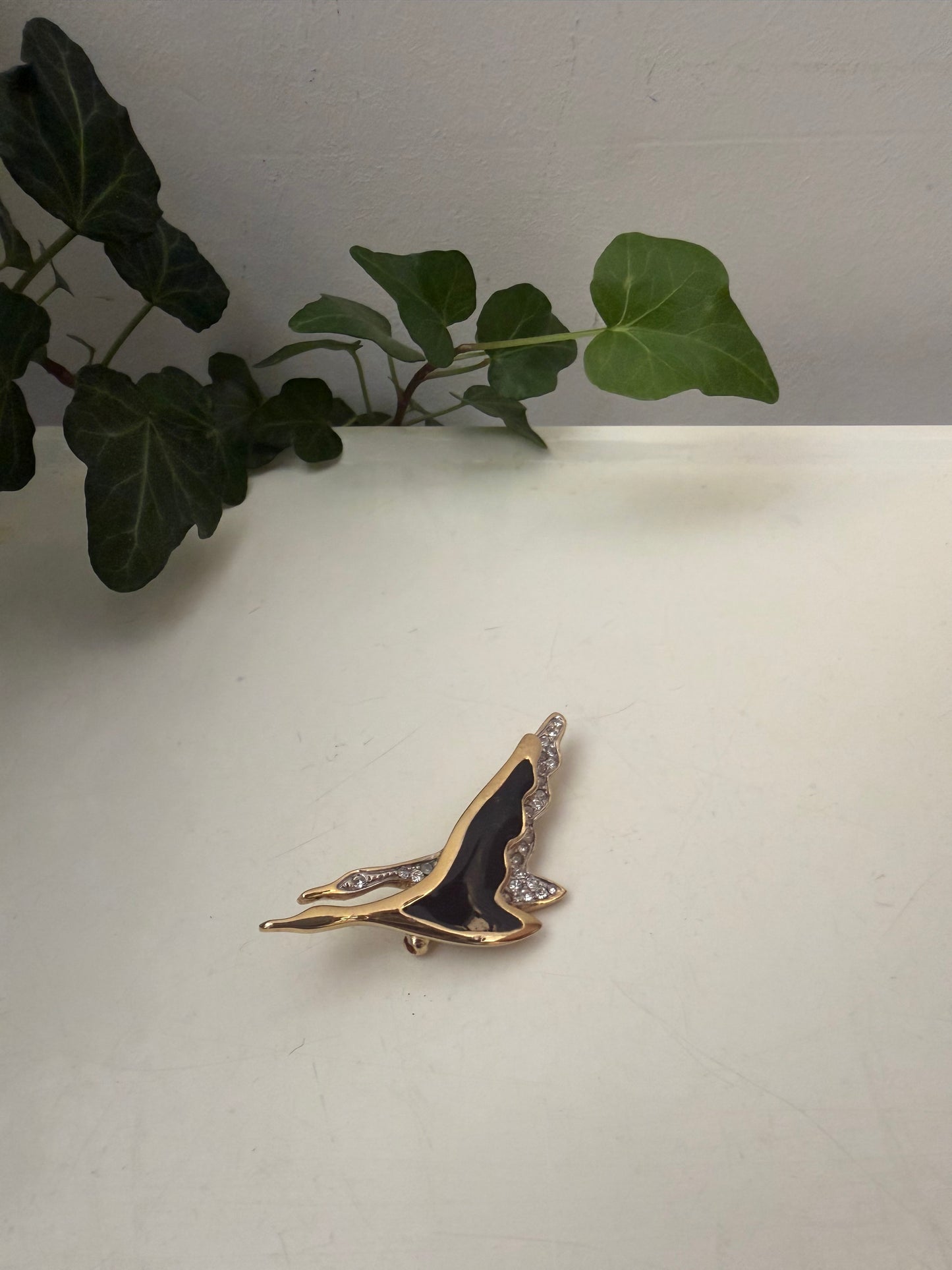 Broche met twee zwanen in zwart en goud kleur