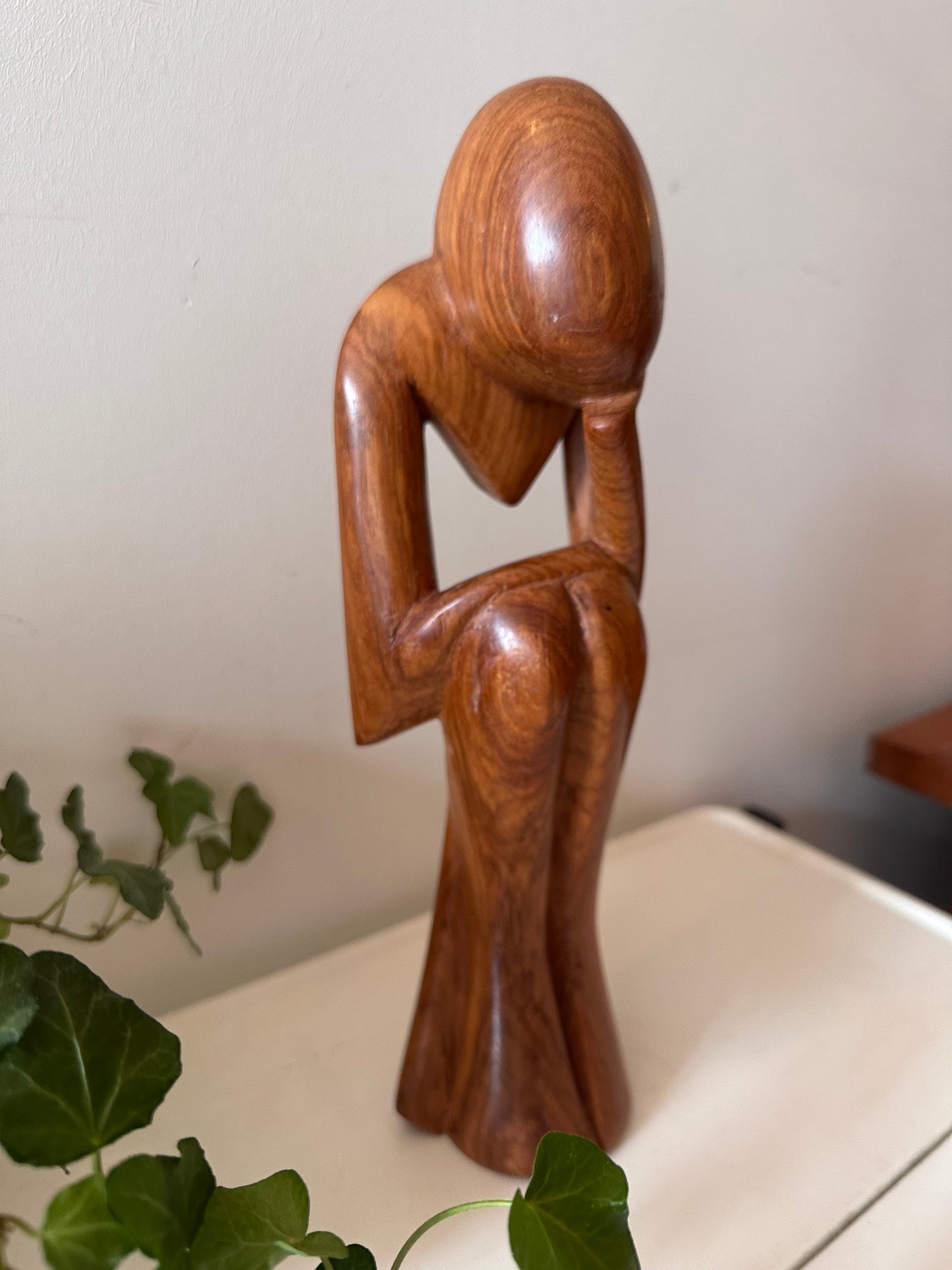 Zittende houten beeldje