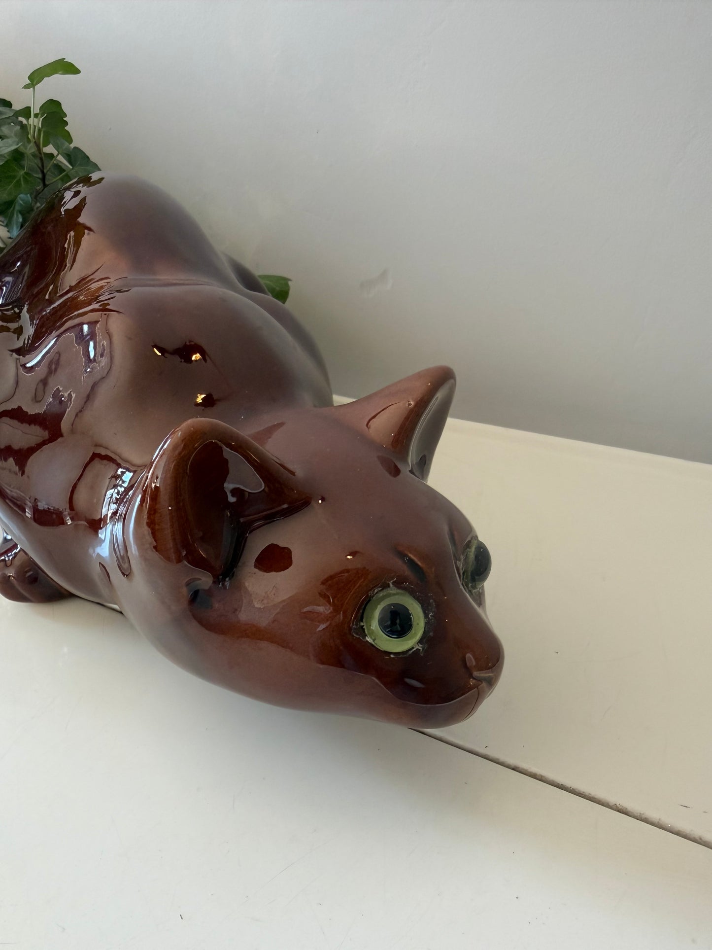 Glanzende keramieken beeld van poes liggend