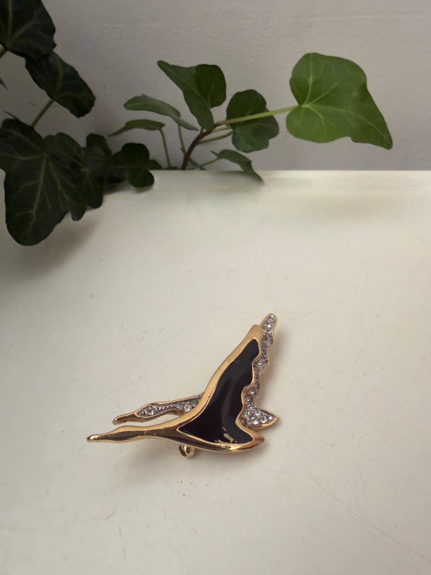 Broche met twee zwanen in zwart en goud kleur