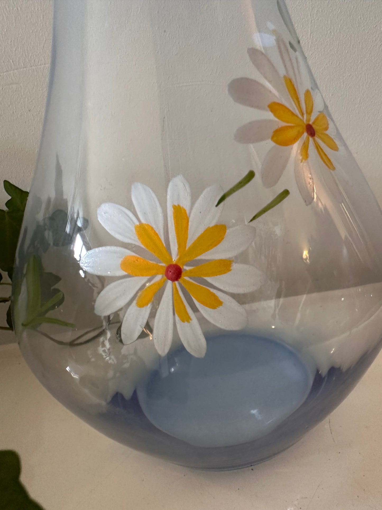 Karaf van blauw glas met margrietjes