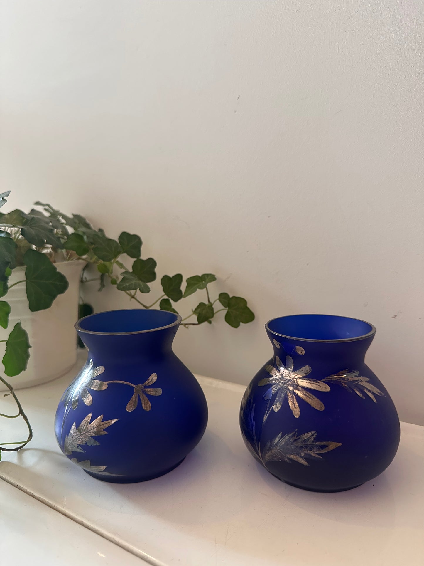 Set van twee blauw glazen vaasjes met gravure in zilver prijs is per stuk!