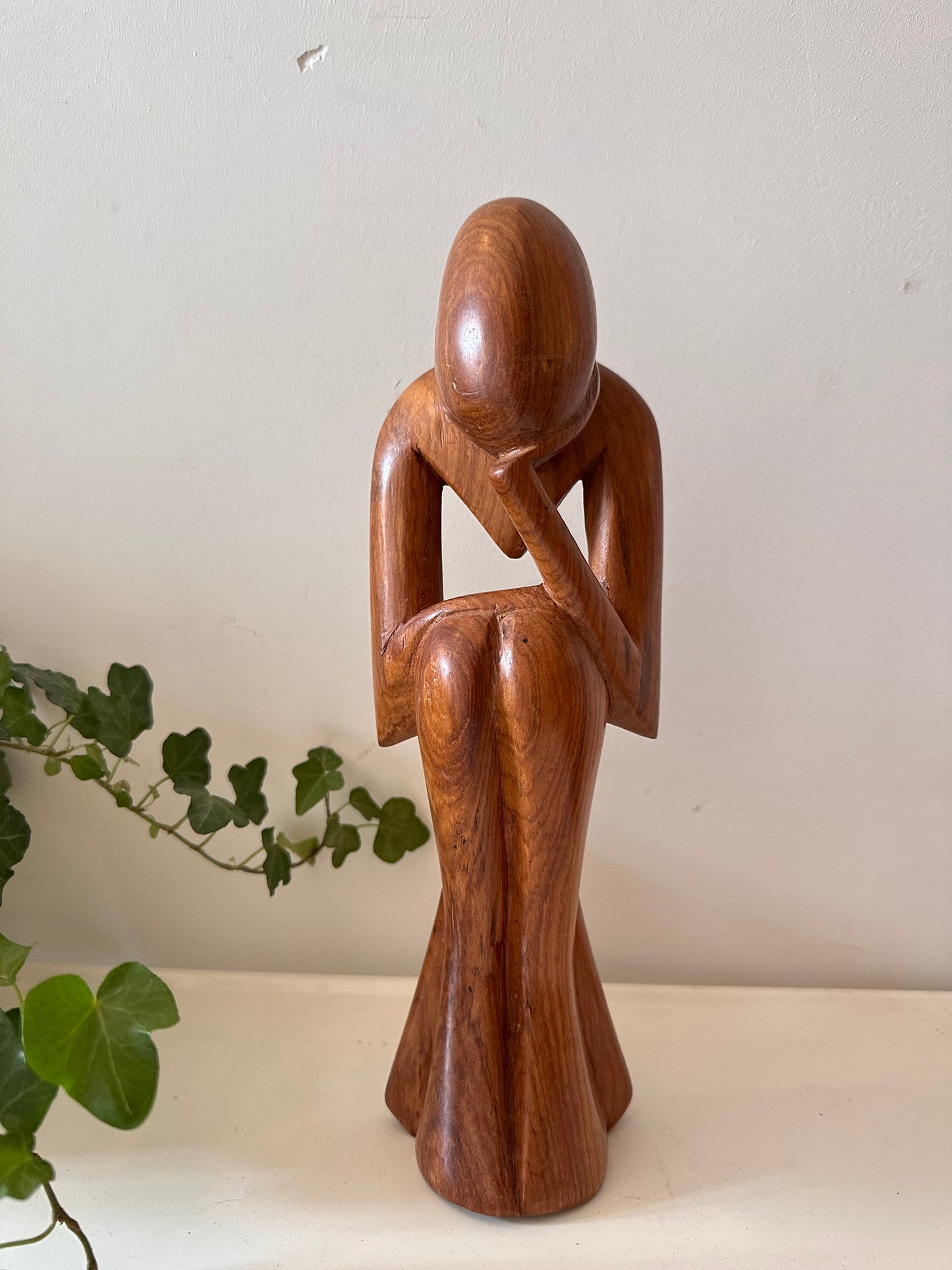 Zittende houten beeldje