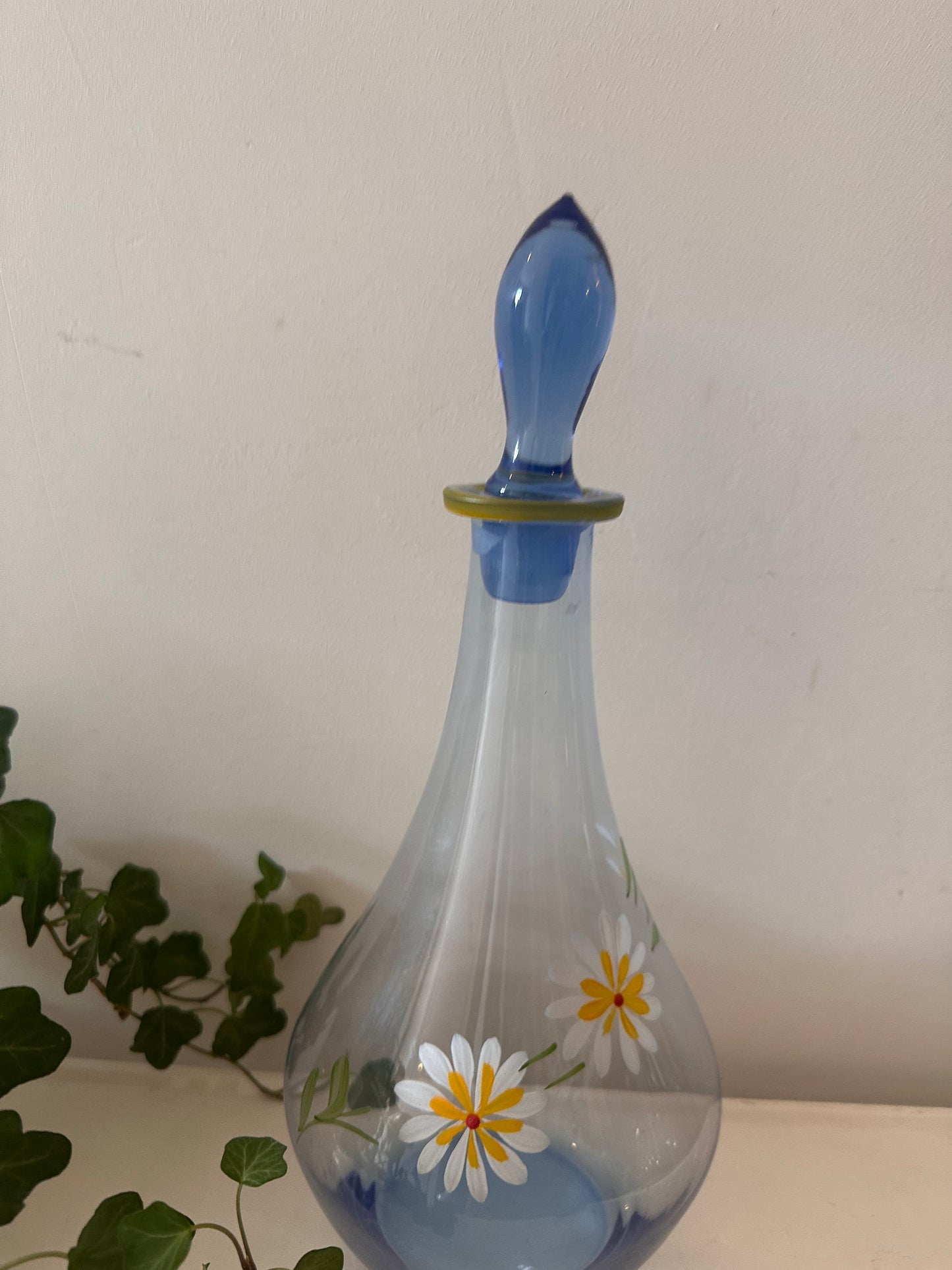 Karaf van blauw glas met margrietjes